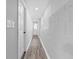 Hallway with clean finishes, hardwood flooring, block accent wall, and white doors at 2735 Varlet Ct, Snellville, GA 30039