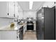 Bright kitchen featuring granite counters, white cabinets, stainless steel appliances, and modern finishes at 2735 Varlet Ct, Snellville, GA 30039