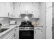Well-lit kitchen with granite countertops, a stainless steel gas range, and modern white cabinetry at 2735 Varlet Ct, Snellville, GA 30039
