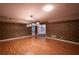 Finished basement with wood-look floors, stylish lighting, and textured wallpaper at 3117 Kings Arms Ne Ct, Atlanta, GA 30345