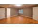 Basement living space includes neutral paint, wood floors, base trim, a window, and multiple doors at 3117 Kings Arms Ne Ct, Atlanta, GA 30345