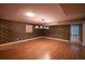 Open finished basement with wood-look flooring, a door, and textured wallpaper at 3117 Kings Arms Ne Ct, Atlanta, GA 30345