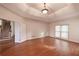 Spacious bedroom with hardwood floors, tray ceiling, recessed lighting, and staircase access at 3117 Kings Arms Ne Ct, Atlanta, GA 30345