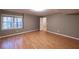 This bedroom has wood floors, a large window, neutral paint, and a door to a closet with shelving at 3117 Kings Arms Ne Ct, Atlanta, GA 30345