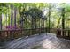 View of a wooden deck with a wooden railing showcasing nature and trees at 3117 Kings Arms Ne Ct, Atlanta, GA 30345