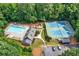 Aerial view of community amenities including a pool, playground, tennis courts, and clubhouse surrounded by trees at 2138 Jockey Hollow Nw Dr, Kennesaw, GA 30152