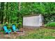 Secluded backyard featuring a fire pit with chairs and storage shed, nestled amongst lush greenery at 2138 Jockey Hollow Nw Dr, Kennesaw, GA 30152