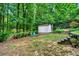 Spacious backyard featuring a storage shed, fire pit with seating area, and lush green surroundings at 2138 Jockey Hollow Nw Dr, Kennesaw, GA 30152