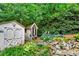 Backyard shed, surrounded by a rock garden and lush greenery, adding charm and storage at 2138 Jockey Hollow Nw Dr, Kennesaw, GA 30152