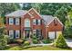 Charming two-story brick home featuring a well-manicured lawn, mature trees, and a two car garage at 2138 Jockey Hollow Nw Dr, Kennesaw, GA 30152