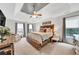 This spacious main bedroom has a tray ceiling, ceiling fan, and large windows providing ample natural light at 2138 Jockey Hollow Nw Dr, Kennesaw, GA 30152