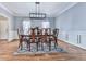 Formal dining room with hardwood floors, a modern chandelier, wainscoting, and a dining set at 5090 Eubanks Rd, Woodstock, GA 30188