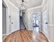 Inviting foyer with a staircase, hardwood floors, and a view into a bedroom at 5090 Eubanks Rd, Woodstock, GA 30188