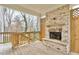 Covered porch with wood-burning brick fireplace and wooden railing at 1300 Winfair Ne Ln, Brookhaven, GA 30329