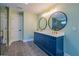 Bathroom featuring a double vanity with round mirrors, gold fixtures, and gray tiled floors at 263 Ohm Ave, Avondale Estates, GA 30002