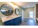 Bathroom featuring a double vanity with round mirrors, gold fixtures, and gray tiled floors at 263 Ohm Ave, Avondale Estates, GA 30002