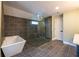 Modern bathroom with a glass-enclosed shower, a soaking tub, and stylish gray tiling at 263 Ohm Ave, Avondale Estates, GA 30002