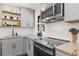 Updated kitchen featuring stainless steel appliances, granite countertops, and open wooden shelving at 282 Oak Se Dr, Atlanta, GA 30354