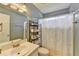 Clean bathroom with a large mirror, shelving unit, and a shower curtain at 639 Oak Moss Dr, Lawrenceville, GA 30043