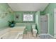 Bright bathroom featuring a soaking tub, walk-in shower and decorative glass-paneled window at 639 Oak Moss Dr, Lawrenceville, GA 30043
