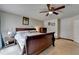 Traditional bedroom with a ceiling fan, beige carpet, and a large wooden bed frame at 639 Oak Moss Dr, Lawrenceville, GA 30043