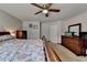 Bright bedroom featuring neutral walls, ceiling fan, dresser, and a floral-patterned bedspread at 639 Oak Moss Dr, Lawrenceville, GA 30043