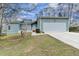 Charming single-story home with a two-car garage and well-maintained lawn, complemented by mature trees at 639 Oak Moss Dr, Lawrenceville, GA 30043