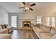 Inviting living room featuring a stone fireplace and neutral-toned sectional sofa at 639 Oak Moss Dr, Lawrenceville, GA 30043