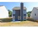 View of the rear exterior featuring the home's siding, windows, chimney, and a spacious grassy yard at 266 Eva Ne Way, Cartersville, GA 30121