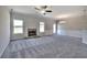 Spacious living room featuring plush gray carpet, a stone fireplace, and abundant natural light streaming through the windows at 266 Eva Ne Way, Cartersville, GA 30121