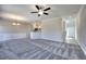 Open-concept living area with modern gray carpet, complemented by a ceiling fan and elegant lighting fixtures at 266 Eva Ne Way, Cartersville, GA 30121