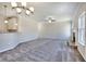Open living area with a partial view of the kitchen, modern gray carpet, and elegant lighting fixtures at 266 Eva Ne Way, Cartersville, GA 30121