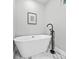 A modern bathroom featuring a standalone white tub, matte black faucet, and marble flooring at 276 Hermer Nw Cir, Atlanta, GA 30311