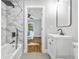 Bright bathroom featuring a large mirror, modern vanity, tub with shower, and gray tile floors at 276 Hermer Nw Cir, Atlanta, GA 30311