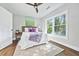 Sun-drenched bedroom featuring hardwood floors, a ceiling fan, a comfortable bed, and bright windows at 276 Hermer Nw Cir, Atlanta, GA 30311