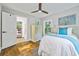 Bright bedroom featuring hardwood floors, a ceiling fan, a comfortable bed, and sunny windows at 276 Hermer Nw Cir, Atlanta, GA 30311
