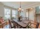 Sunlit dining room with wood floors, large windows, wainscoting, and a view to stairway at 3452 Village Park Sw Ln, Atlanta, GA 30331