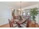Dining room boasts wainscoting, wood floors, and a unique chandelier with view to foyer staircase at 3452 Village Park Sw Ln, Atlanta, GA 30331