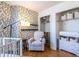 Bedroom featuring a crib, chair, accent wall, and closet at 1346 Stillwood Chase Ne, Atlanta, GA 30306
