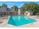 Inviting community pool area with lounge chairs, umbrellas, and lush landscaping surrounded by beautiful building architecture at 3655 Habersham Ne Rd # 215, Atlanta, GA 30305