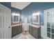 Bathroom featuring dual sinks with decorative mirrors and a tall storage cabinet at 4118 Kentmere Main Nw, Kennesaw, GA 30144