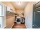 Practical laundry room with modern washer and dryer, and storage shelving at 4118 Kentmere Main Nw, Kennesaw, GA 30144