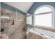 Large walk-in shower with rainfall showerhead and soaking tub by an arched window at 4118 Kentmere Main Nw, Kennesaw, GA 30144