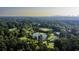 Aerial view of a community with a pond, golf course, tennis court, and the city skyline in the background at 47 Monet Nw Ct, Atlanta, GA 30327