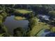 Aerial view featuring a pond, golf course, tennis court, swimming pool, and luxurious clubhouse at 47 Monet Nw Ct, Atlanta, GA 30327