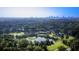 Aerial view of a community with a pond, golf course, tennis court, and the city skyline in the background at 47 Monet Nw Ct, Atlanta, GA 30327