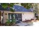 Exterior view of a light brick building with gray roof, black doors, and green bushes at 47 Monet Nw Ct, Atlanta, GA 30327