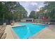 A beautiful community swimming pool surrounded by lounge chairs, picnic tables, and green trees at 47 Monet Nw Ct, Atlanta, GA 30327