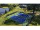 Aerial view of blue and green tennis courts near a pond and next to trees and green grass at 47 Monet Nw Ct, Atlanta, GA 30327