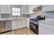 Well-lit kitchen with modern appliances, white cabinets, and ample counter space at 6776 Gina Agha Cir, Lithonia, GA 30038